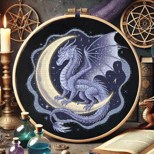 Könnte beinhalten: Ein lila Drache mit Flügeln sitzt auf einem Halbmond vor einem dunkelblauen Hintergrund mit Sternen. Der Drache ist auf einem runden Reifen gestickt.