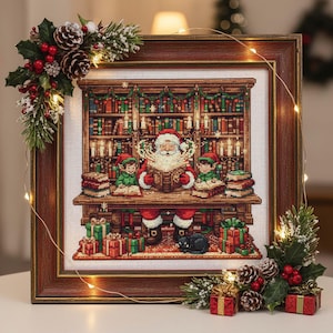Könnte beinhalten: Ein gerahmtes Kreuzstichbild, das den Weihnachtsmann beim Lesen eines Buches mit zwei Elfen in einer Bibliothek zeigt. Die Szene ist mit Büchern, Kerzen und Geschenken gefüllt. Der Rahmen ist braun und das Bild ist mit Tannenzapfen und Beeren verziert.