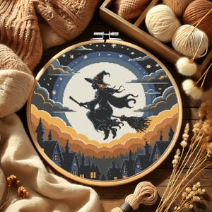 May include: A cross-stitch embroidery hoop featuring a Halloween design. The artwork depicts a witch flying on a broom in front of a full moon, with a town silhouette below. The color palette includes shades of blue, orange, and black.