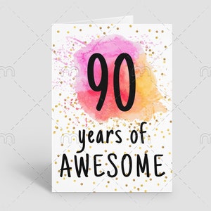 May include: A white card with gold glitter confetti and a pink and orange watercolor background. The number 90 is written in black in the center of the card. The text "years of AWESOME" is written in black below the number.
