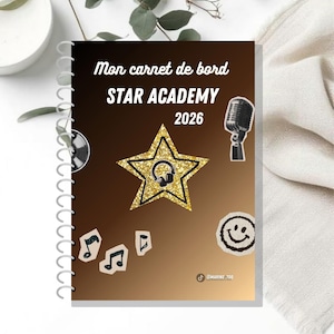 Op de afbeelding: Een spiraalgebonden notitieboek met een bruine gradiënt omslag met de tekst Mon carnet de bord STAR ACADEMY 2026. Het ontwerp bevat een gouden glitterster met een koptelefoon, een microfoon, muzieknoten en een smiley-icoon.