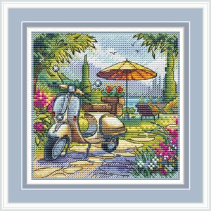May include: Cross-stitch picture of a vintage scooter on a cobbled path. The scene includes an orange parasol, flowers, and a sea view. The artwork is framed in a light blue border.