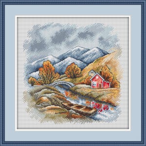 May include: Cross-stitch landscape depicting a red house, bridge, and boat on a river. The scene includes mountains, trees with orange and yellow leaves, and a cloudy sky. The artwork is framed in a blue border.