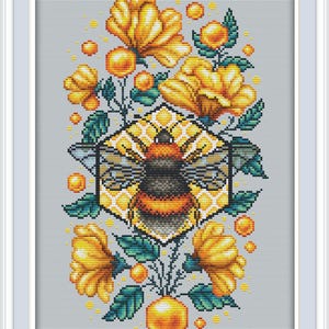 May include: Cross-stitch design with a bee at the centre, encircled by yellow flowers, green leaves, and golden orbs. The bee is within a honeycomb-shaped frame. The background is light grey, and the design is framed in white.