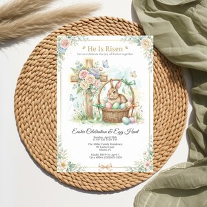 May include: An Easter invitation with watercolour illustrations. The design features a cross, a bunny in a basket with eggs, and floral accents. Text includes "He Is Risen" and details for an Easter celebration and egg hunt.