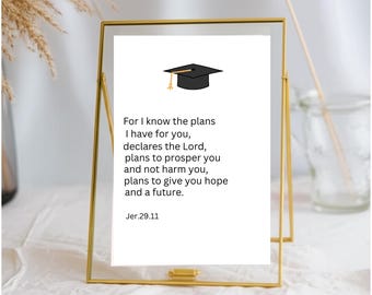 May include: A gold-toned metal frame holding a white card with a black graduation cap icon and the text: For I know the plans I have for you, declares the Lord, plans to prosper you and not harm you, plans to give you hope and a future. Jer.29.11