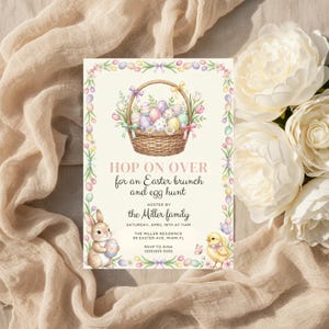May include: An Easter brunch invitation with a watercolor illustration. The invitation features a basket of Easter eggs, a bunny, and a chick. Text reads "Hop on over for an Easter brunch and egg hunt".