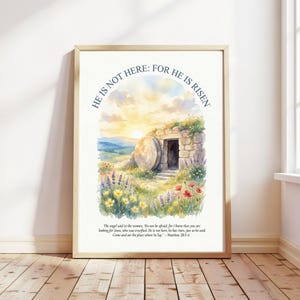 Puede incluir: Impresión en acuarela enmarcada. La obra representa una tumba abierta con un amanecer al fondo. El texto dice "HE IS NOT HERE: FOR HE IS RISEN" y una cita bíblica. La escena incluye flores silvestres y un paisaje ondulado.