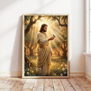 Op de afbeelding: Een ingelijste kunstdruk met een figuur met lang bruin haar en een baard, gekleed in een beige gewaad, staand in een zonnig bos. De figuur houdt een kleine vogel op de hand, omringd door witte bloemen en zacht, goudkleurig licht.