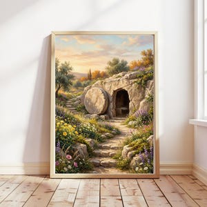 Puede incluir: Una impresión enmarcada de una pintura de paisaje que representa una tumba de piedra con una gran piedra redonda que bloquea la entrada. La escena incluye un camino, escaleras y coloridas flores silvestres. El cielo es una mezcla de naranja, amarillo y azul.