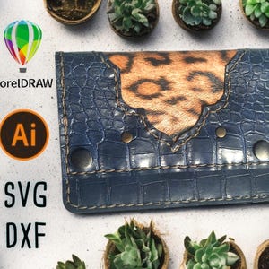 Puede incluir: Una cartera de cuero azul con un diseño de estampado de leopardo marrón. La cartera tiene un borde cosido y remaches metálicos. CorelDRAW, Ai, SVG y DXF están listados debajo de la cartera.