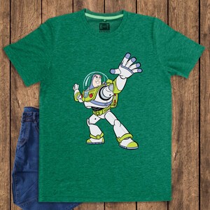 May include: Green t-shirt featuring a cartoon illustration of Buzz Lightyear from Toy Story. The character is depicted in his signature space ranger suit, with a white and green color scheme. The shirt has a crew neck and the brand name "Karate Apparel" is visible.
