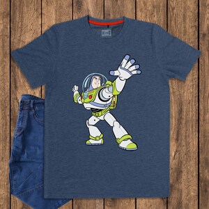May include: A navy blue t-shirt featuring a cartoon illustration of Buzz Lightyear from Toy Story. The character is depicted in his signature white and green spacesuit, with his arm raised. The shirt is paired with a pair of blue jeans.
