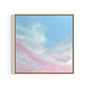 Könnte beinhalten: Quadratisch gerahmtes Kunstwerk mit einer Himmelsansicht. Das Kunstwerk zeigt einen hellblauen Himmel mit flauschigen weißen Wolken und rosa Wolkenstreifen. Der Rahmen ist hellbeige.