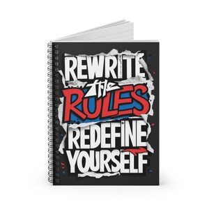 May include: A black spiral notebook with a motivational quote: "Rewrite the Rules Redefine Yourself". The quote is in white, red, and blue lettering with a torn paper effect.