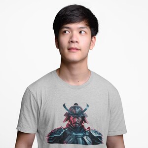 May include: A gray t-shirt with a graphic print of a samurai warrior wearing a helmet with horns. The warrior's face is visible and has a serious expression.