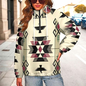 May include: Cream-colored zip-up jacket with a geometric pattern in black, burgundy, and green. The jacket features a high collar, a drawstring, and a tribal-inspired design. The jacket is worn with blue jeans.