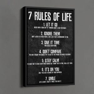 May include: Black framed canvas art with the text "7 Rules of Life" in white. The rules include "Let it Go," "Ignore Them," "Give it Time," "Don't Compare," "Stay Calm," "It's on You," and "Smile." The canvas is displayed on a gray wall.