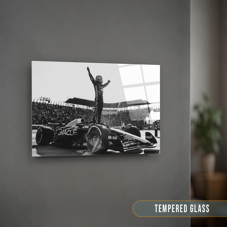 May include: Black and white print of a Formula 1 race car with a driver standing on top, arms raised in victory. The car has sponsor logos including "Oracle" and "Mobil." The image is displayed on a wall with the text "TEMPERED GLASS" at the bottom.