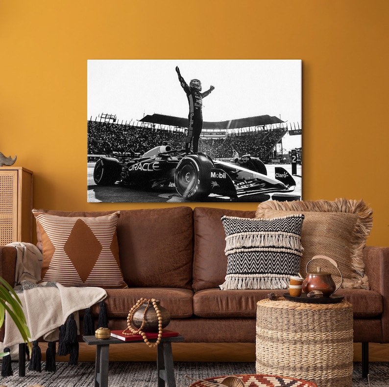 May include: Black and white canvas print of a Formula 1 race car with a driver standing on top, arms raised in victory. The car has the Oracle and Mobil logos. The background shows a packed stadium.
