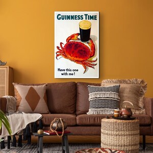 May include: A vintage Guinness advert featuring a red crab holding a glass of Guinness beer. The text reads "GUINNESS TIME" and "Have this one with me!"