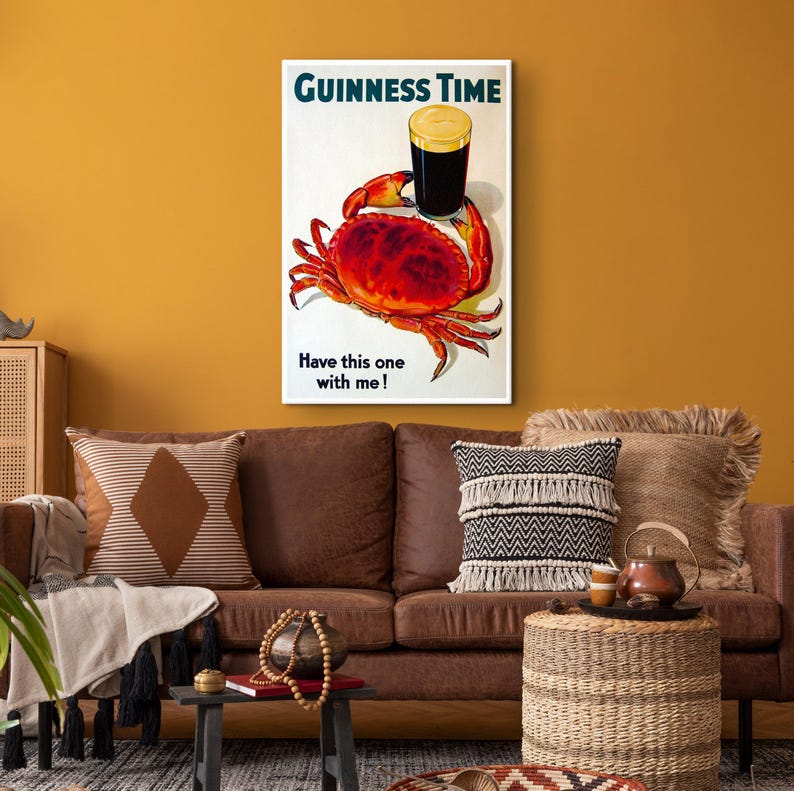 May include: A vintage Guinness advert featuring a red crab holding a glass of Guinness beer. The text reads "GUINNESS TIME" and "Have this one with me!"