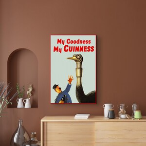 May include: A vintage advertisement for Guinness beer featuring a man in a blue uniform holding a bottle of Guinness and an ostrich with the text "My Goodness My GUINNESS".