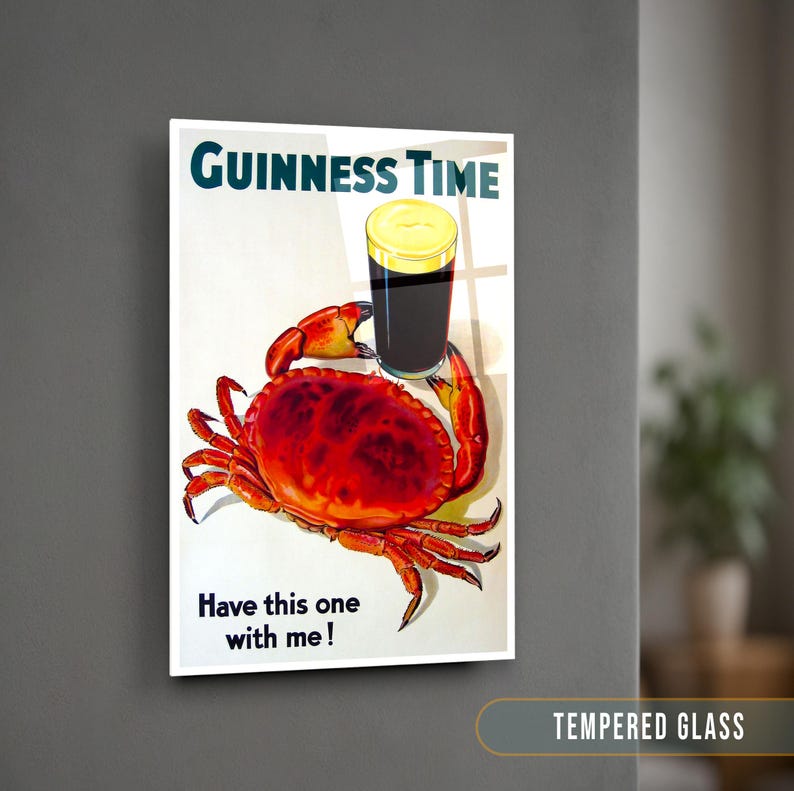 May include: A vintage-style poster advertising Guinness beer. The poster features a red crab with a glass of Guinness beer on top of it. The text on the poster reads "GUINNESS TIME" and "Have this one with me!"