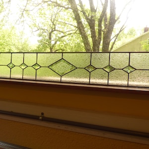 May include: A white ceramic mug with a black handle and the text "But First, Coffee" in a handwritten style. The mug is on a white surface. The mug is likely for hot beverages.