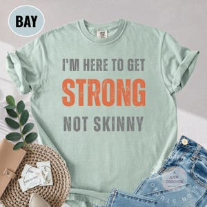 Maglietta Comfort Colors® Strong Not Skinny / Maglietta da palestra con motivazione per il fitness / Maglietta con citazione per l'allenamento / Regalo per il sollevamento pesi / Maglietta per ragazze fitness