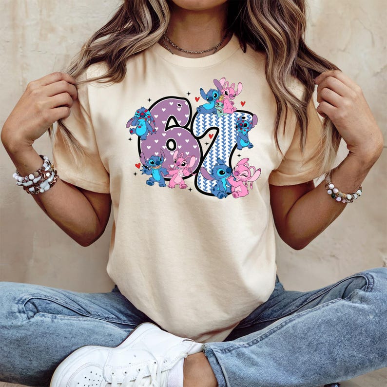 A woman wearing a white t-shirt with a graphic design featuring the number 67 and various cartoon characters.