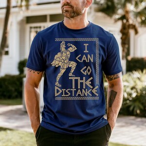 A man wearing a blue t-shirt with a graphic design and text printed on it.