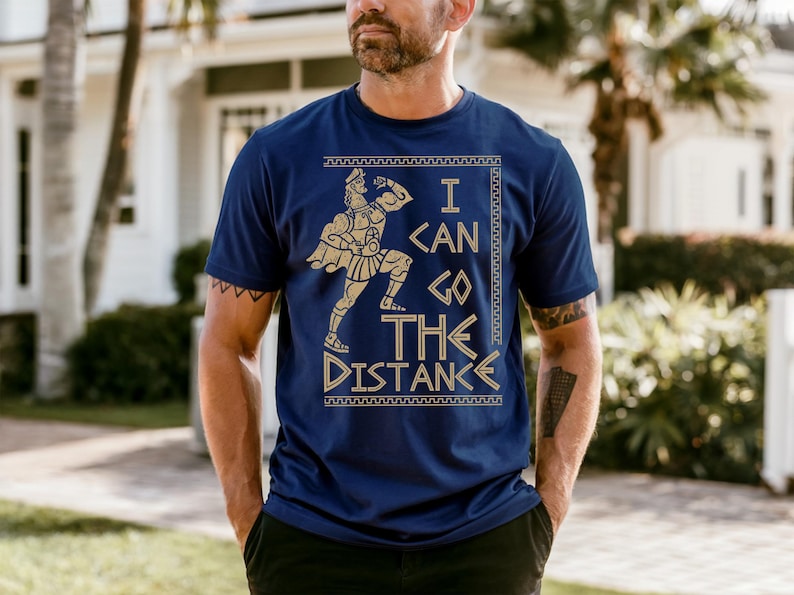 A man wearing a blue t-shirt with a graphic design and text printed on it.