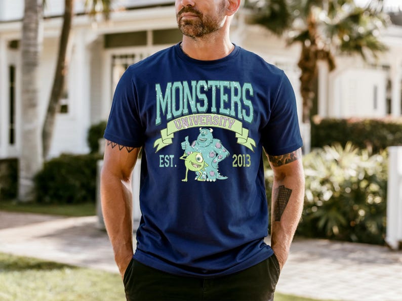 A man wearing a blue t-shirt with a graphic design of a character from the animated movie Monsters University.