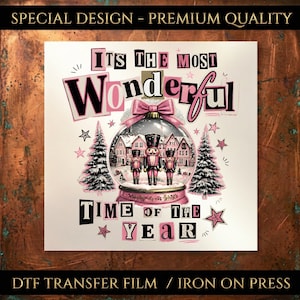 May include: A DTF transfer film featuring a snow globe with three nutcrackers and a house inside. The text reads "ITS THE MOST WONDERFUL TIME OF THE YEAR" in black and pink letters. The design includes pink bows, stars, and two pine trees.