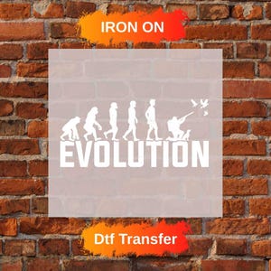 Peut inclure: Transfert DTF blanc avec le mot "EVOLUTION" et un graphique représentant l'évolution humaine. L'image comprend le texte "IRON ON" et "Dtf Transfer" en orange et rouge.