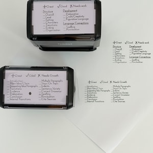 May include: Four black and white rubber stamps with different categories for grading writing. The categories include structure, development, introduction, main idea/claim, supporting idea paragraphs, transitions, evidence, elaboration, conclusion, internal transitions, multiple paragraphs, stays on topic, indents, sentence variety, correct grammar, spelling, punctuation, and cite sources.