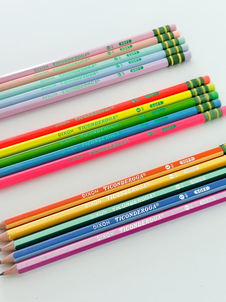 May include: A collection of colorful Dixon Ticonderoga pencils. The pencils are arranged in rows, showcasing a variety of vibrant colors including pink, orange, yellow, green, blue, and purple. Each pencil has the brand name printed on it and a green eraser.