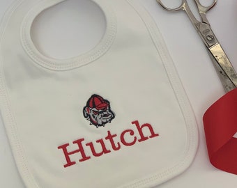May include: White baby bib with red embroidered bulldog mascot and the name Hutch.