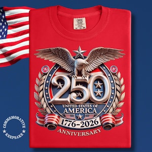 May include: Red t-shirt featuring a detailed emblem commemorating the 250th anniversary of the United States of America. The design includes a spread-winged eagle, the number "250", stars, and the years 1776-2026.