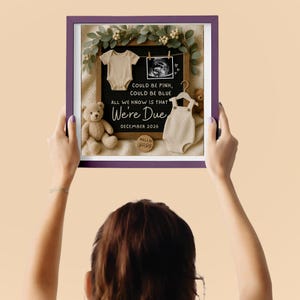 Neutral baby announcement flat lay featuring a black felt letter board with the text “Could be pink, could be blue, all we know is that we’re due. December 2026.” A baby ultrasound photo, beige baby onesie, and cream romper are clipped to the board. Surrounded by eucalyptus greenery, two plush teddy bears, and a small wooden sign reading “Hello Baby.” Warm, earthy tones with a cozy aesthetic.