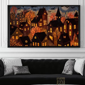 May include: A framed art print depicts a nighttime cityscape with illuminated houses and autumn trees. The artwork features a dark color palette with warm orange and yellow lights, bats, and a full moon, creating a spooky Halloween theme.