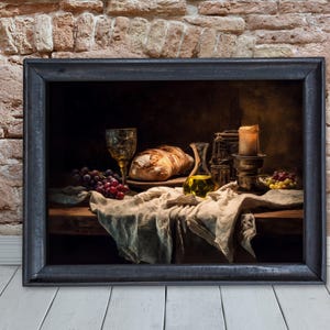 May include: A framed still life painting featuring a loaf of bread, grapes, a glass of wine, and a bottle of olive oil. A lit candle and a draped cloth complete the scene. The painting is set against a brick wall and a wooden floor.