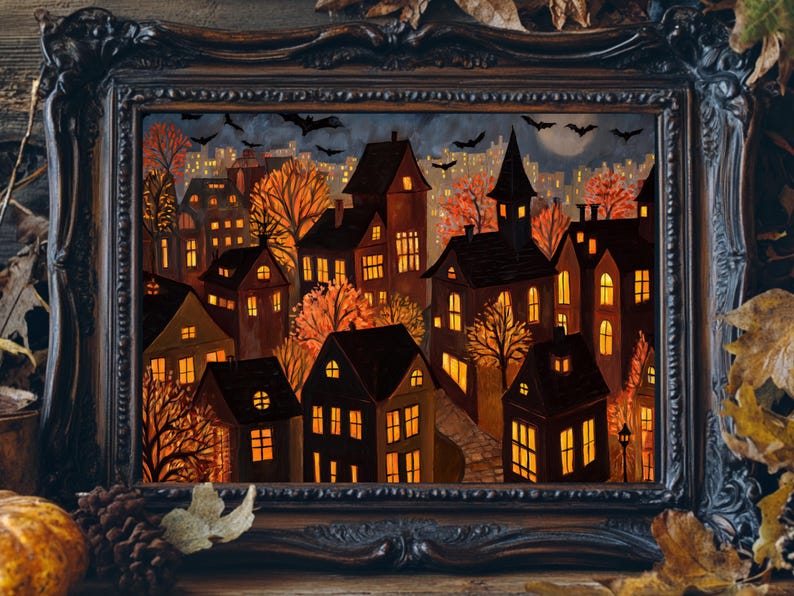 May include: A framed painting depicts a nighttime Halloween scene. The artwork features illuminated houses, orange trees, and bats against a dark sky. The ornate black frame adds a vintage touch to the spooky artwork.