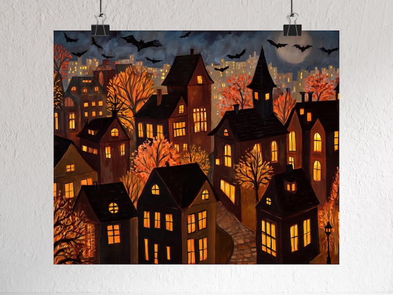 May include: A print of a spooky town at night, featuring dark houses with glowing windows and orange trees. Bats fly in the night sky above the town, with a full moon in the background. The artwork has a Halloween theme.