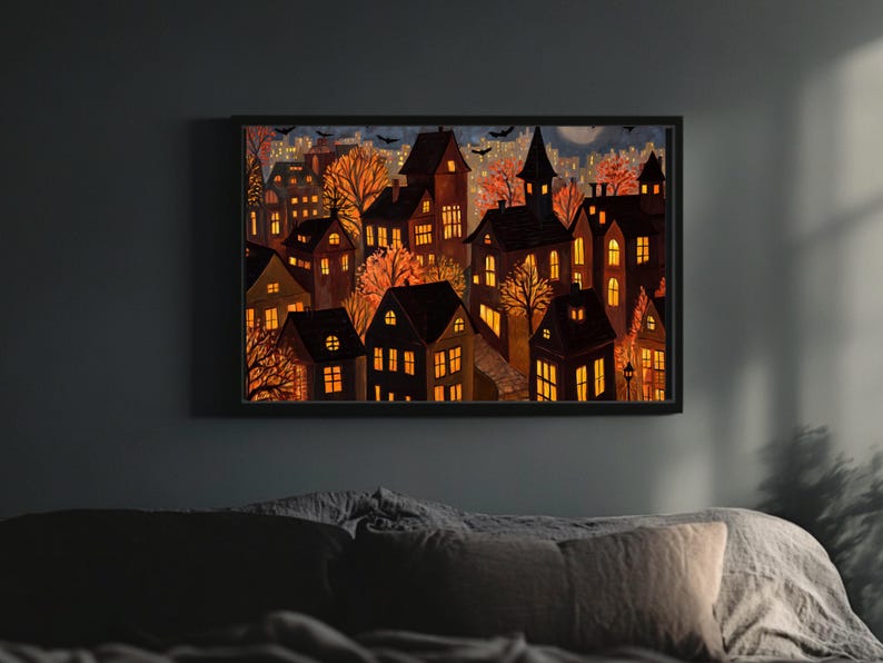 May include: A framed watercolor painting depicts a nighttime cityscape with illuminated houses and trees in autumn colors. The artwork features a dark sky with bats and a full moon, creating a spooky, Halloween-themed scene.