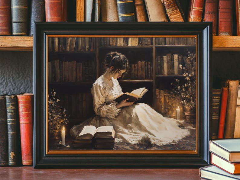 May include: A framed painting depicting a woman in a white dress reading a book in a library setting. The woman is seated on the floor with a book in her lap and a candle lit on the floor beside her. The library shelves are filled with books and there is a soft glow of light emanating from the candle.