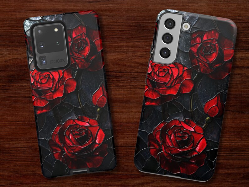 Pu&ograve; includere: Una custodia per telefono nera con sfondo scuro e rose rosse. La custodia ha un ritaglio per la fotocamera e un bordo argentato.