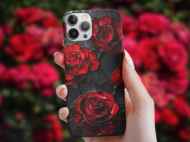Pu&ograve; includere: Una custodia per telefono nera con un design di rose rosse su uno sfondo scuro. La custodia ha un ritaglio per l'obiettivo della fotocamera e un design elegante e moderno.