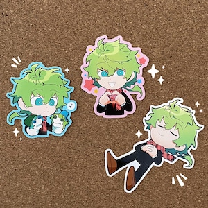 May include: Three stickers featuring a cartoon character with green hair and a red and white scarf. The character is shown in three different poses: holding a heart, holding two small green creatures, and sleeping. The stickers are on a brown corkboard background.